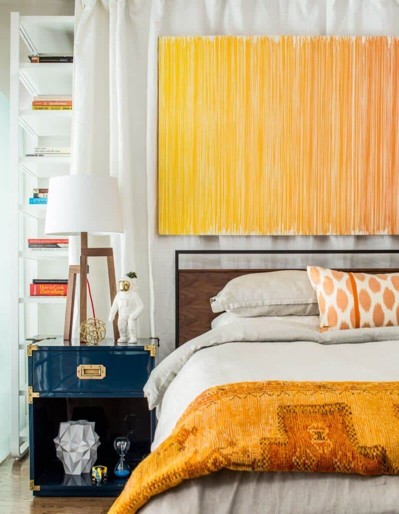 orange painting behind a bed